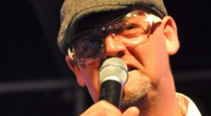 DJ Dominick als MC met een groovy bril en petje.