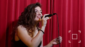 Jazz zangeres Ann Louise (Janneke Teijen) treed op voor een rood gordijn.